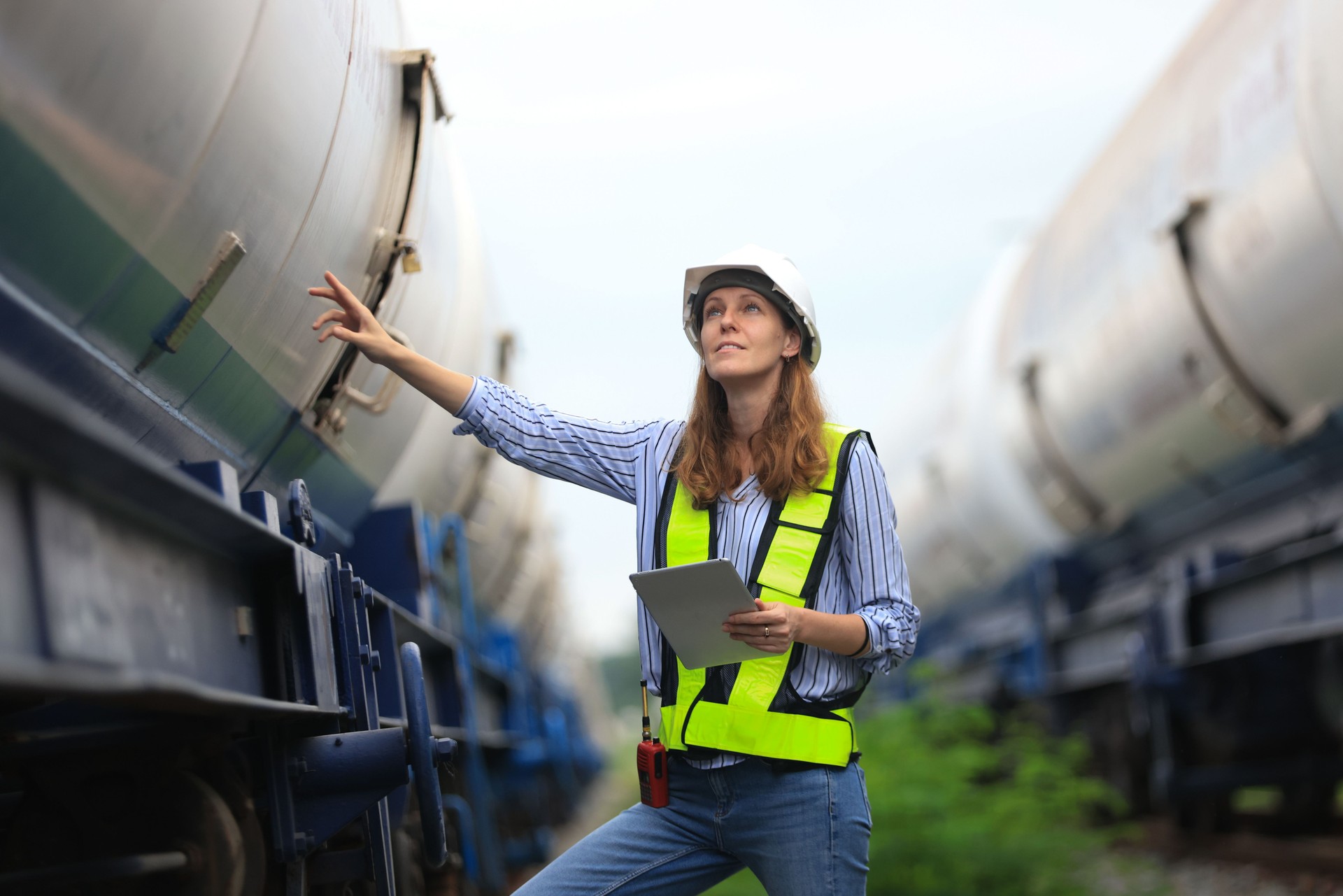 Female warehouse and chemical arrangement  senior engineer working at  A station designed for transporting oil and gas products in specialized tanks, utilizing train transport on tracks